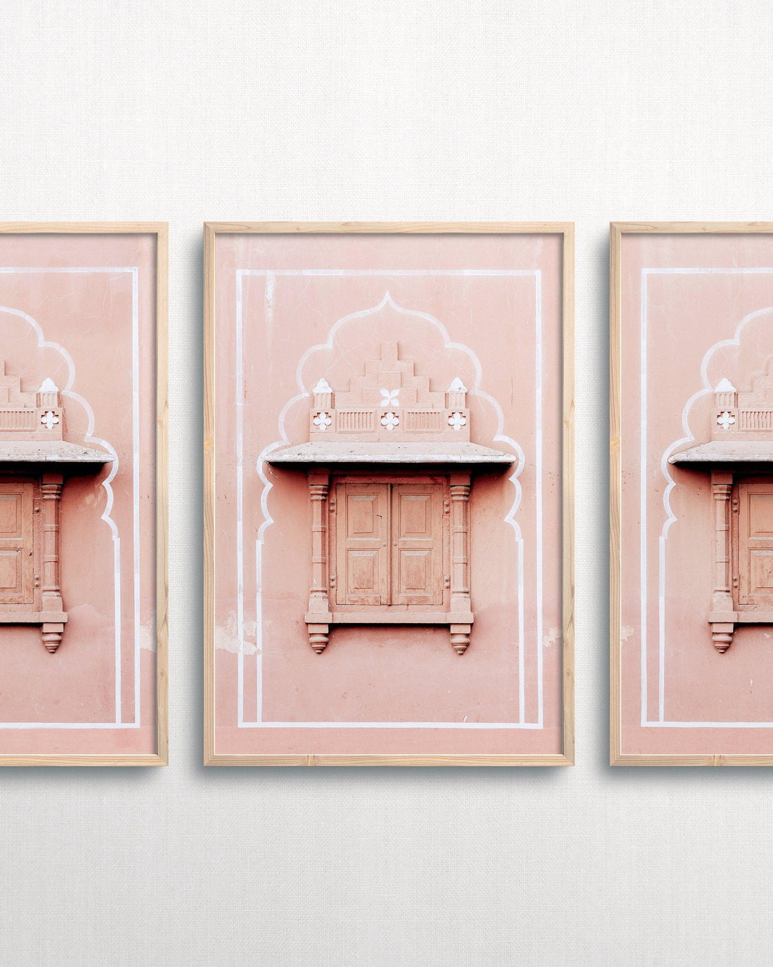 framed art piece on white wall. Photograph of pink architecture in India in frame