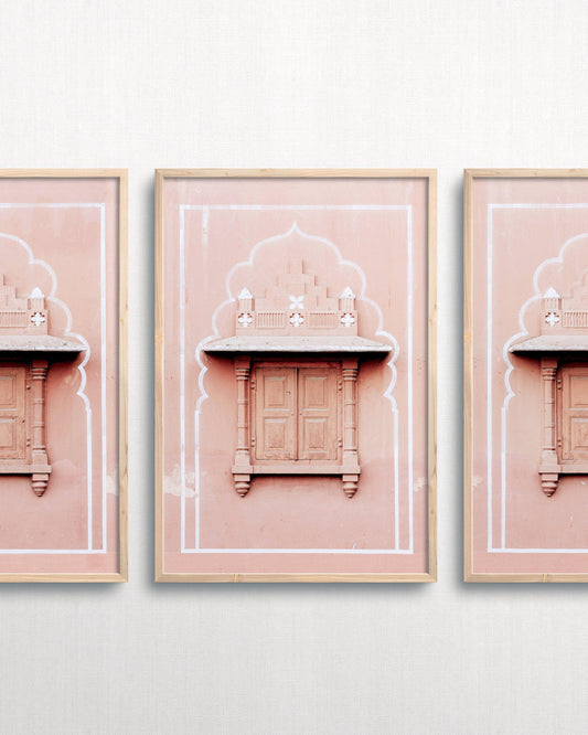 framed art piece on white wall. Photograph of pink architecture in India in frame