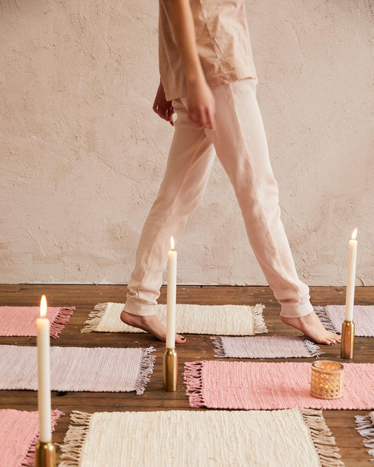 girl walking on top of rug placemats, candles lit on floor