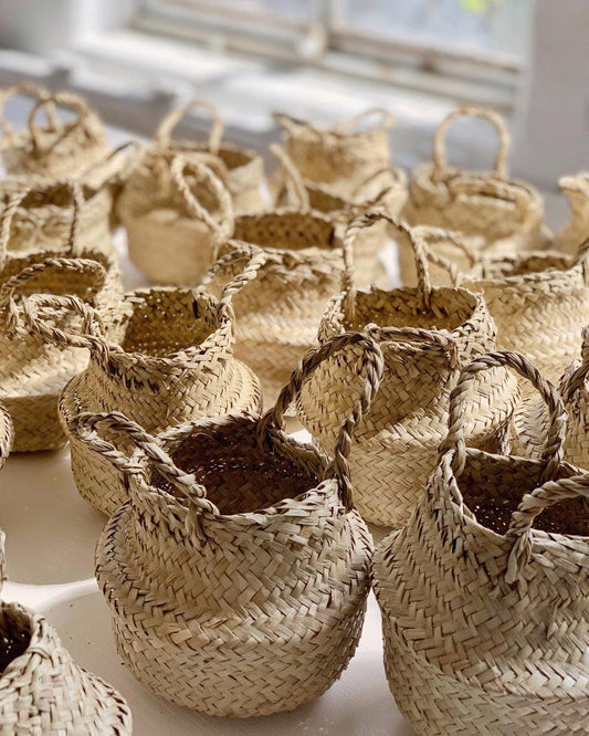 rows of empty handwoven palm belly baskets on windowsill